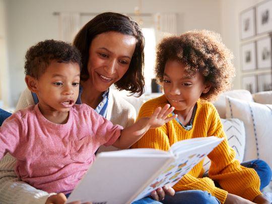 Foster parent reading a story to her two foster children